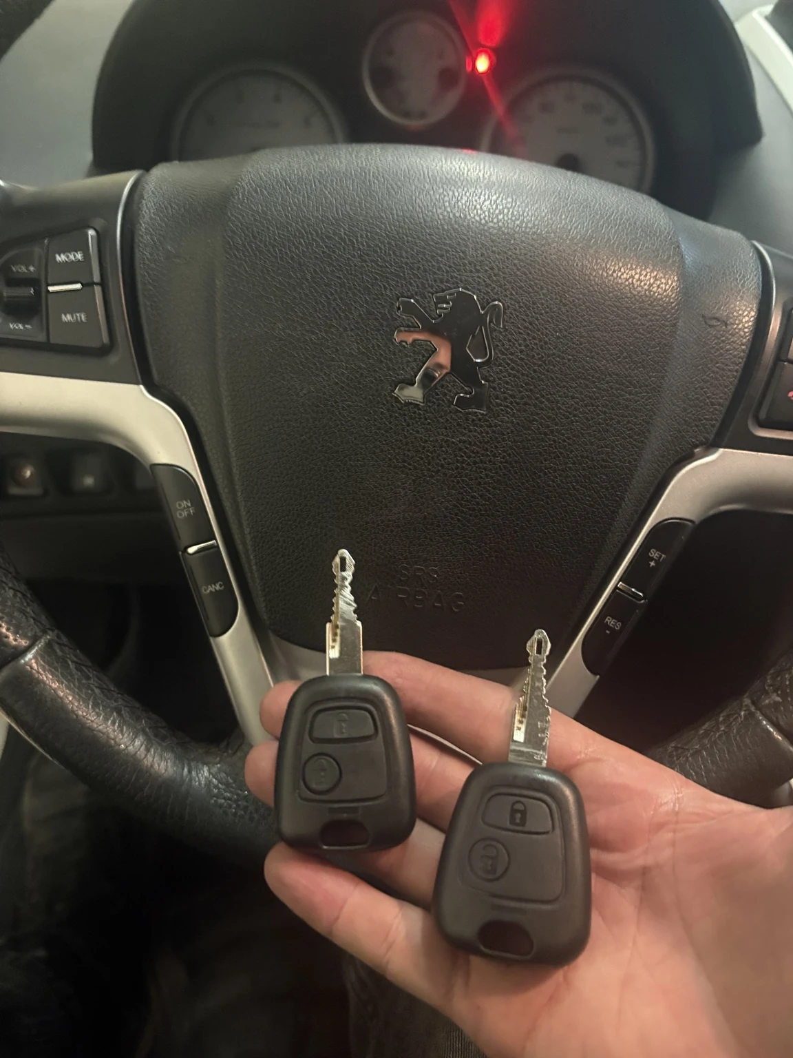 عکس واقعی دو سوئیچ و ریموت پژو ۲۰۷ در مقابل فرمان خودرو، نمونه خدمات ساخت سوئیچ KEYLINE369